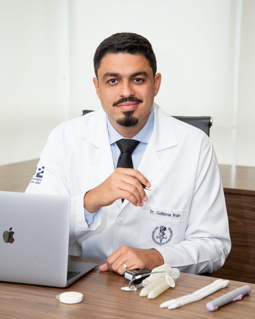 IMG_9080 Dr. especialista em urologia trabalhando em seu consultório, com computador e materiais de exame ao lado